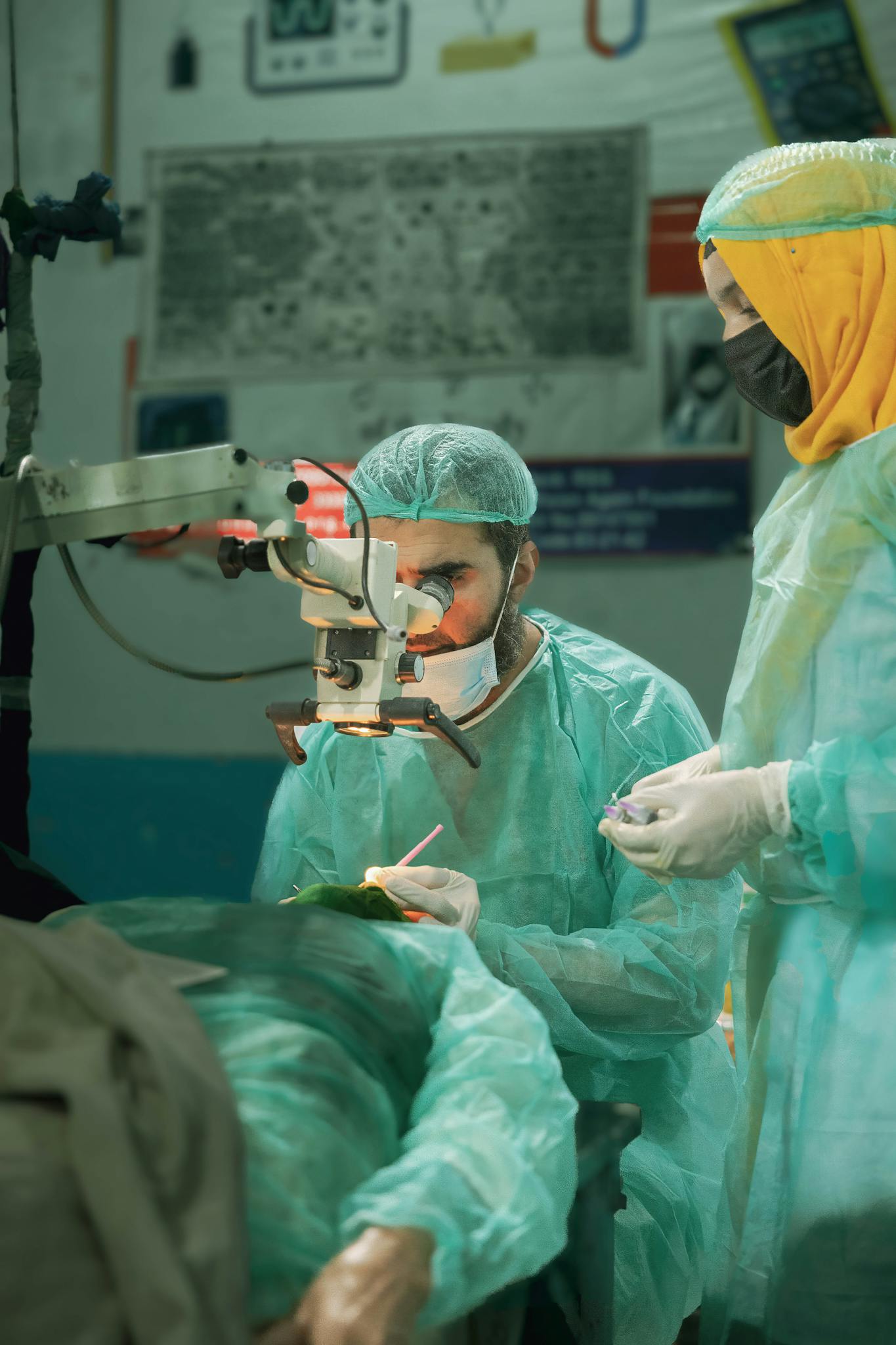 Two surgeons performing eye surgery in an operating room with gloves and masks.